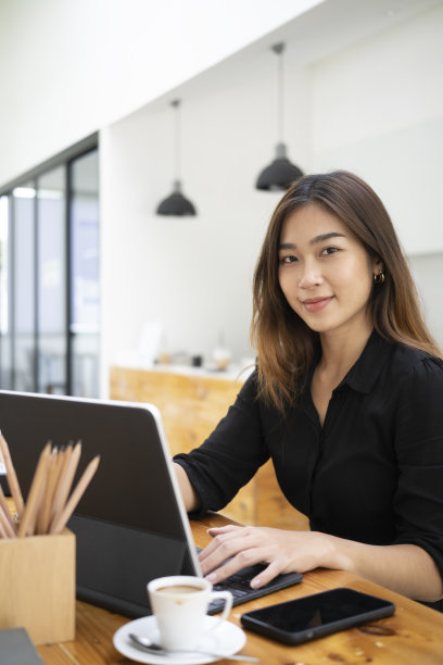 美丽的女商人用着平板电脑看着相机。图片下载