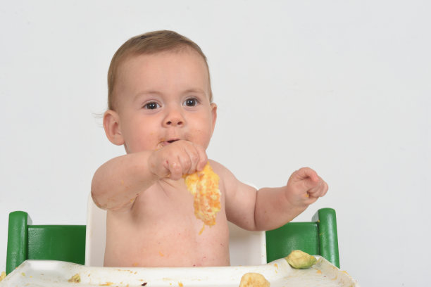 婴儿坐在架子上玩着食物图片下载