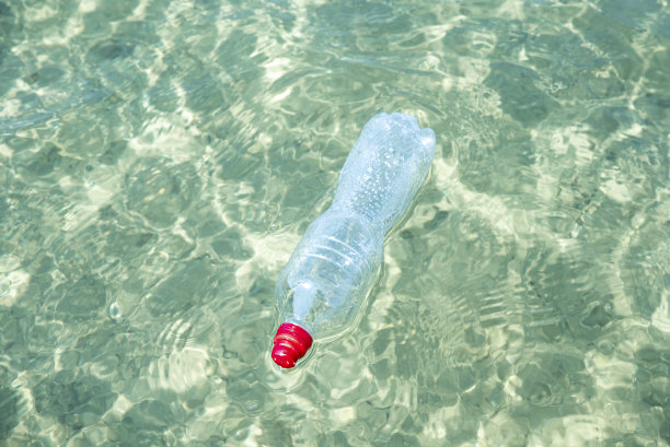 塑料瓶在池塘里。污染的概念。图片下载