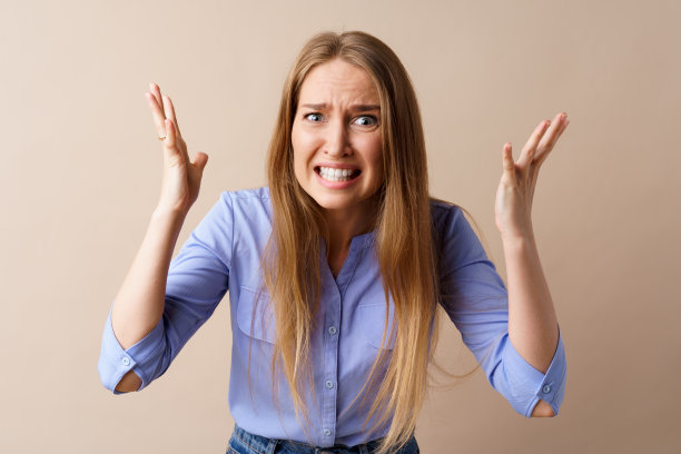 愤怒的压力疯狂的年轻女子对米色背景图片下载