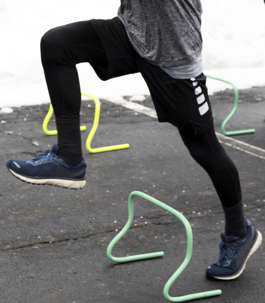 跑步者正跨过一个绿色的迷你栏图片下载