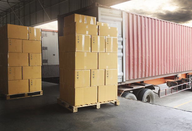 装载货物集装箱的包装箱堆叠。停靠在码头仓库装载货物的拖车。送货服务。发货仓库物流。货物、货车运输。图片下载