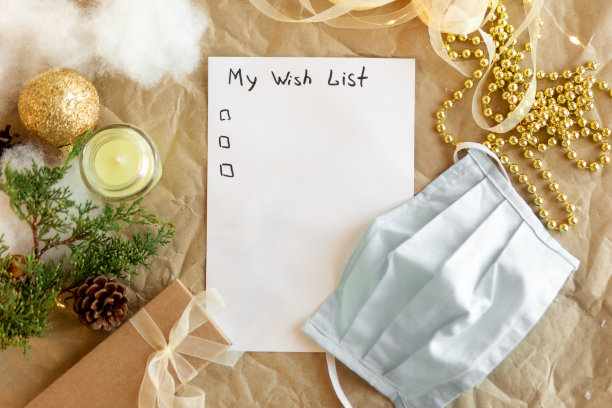 写着我2022年愿望清单的笔记本。金色的圣诞装饰，冷杉枝。医学的面具。新年和假期的概念与计划礼物。前视图。Flatlay图片下载