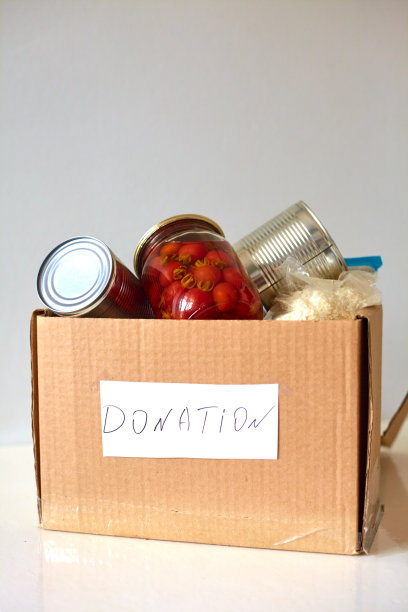 盒子里装着慈善捐赠的食物。罐头食品，意大利面，腌番茄，蔬菜，米饭。食品配送或食品捐赠理念。图片下载