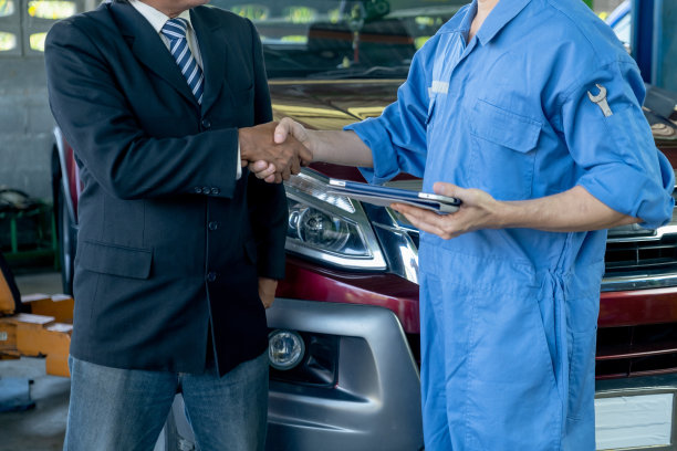 汽车技师在工作场所与客户在车前握手解决问题图片下载