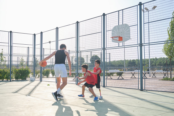 三个兄弟打篮球，其中一个装有假肢。兄弟姐妹打篮球。图片下载