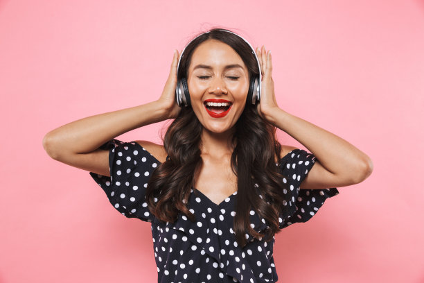 穿着衣服戴着耳机听音乐的黑发女人很高兴图片下载