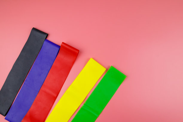 一套弹性橡皮筋为健身在粉红色的背景。俯视图图片下载