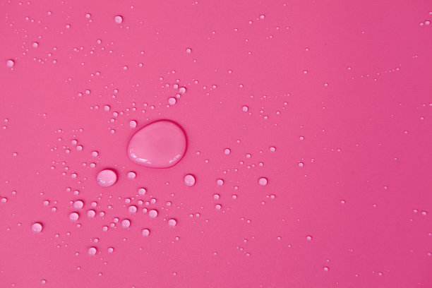 由气泡和水滴形成的纹理的完整框架。水滴洒在浅粉色的表面上图片下载