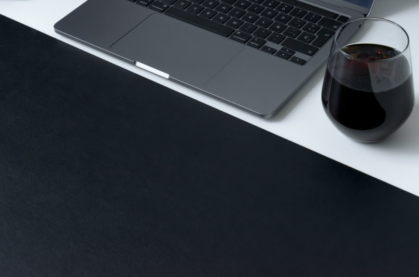 用笔记本电脑、咖啡和白色办公桌上的哑光黑色工作台来清洁现代的工作空间图片下载