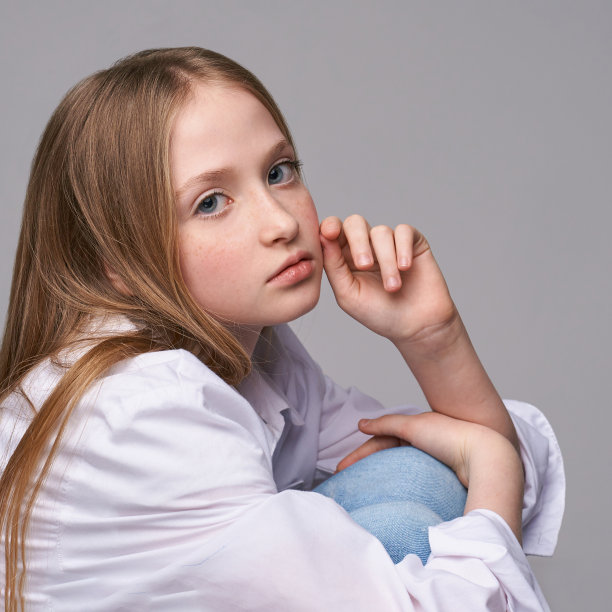 年轻漂亮的女孩。严肃的模特，手靠近脸图片下载