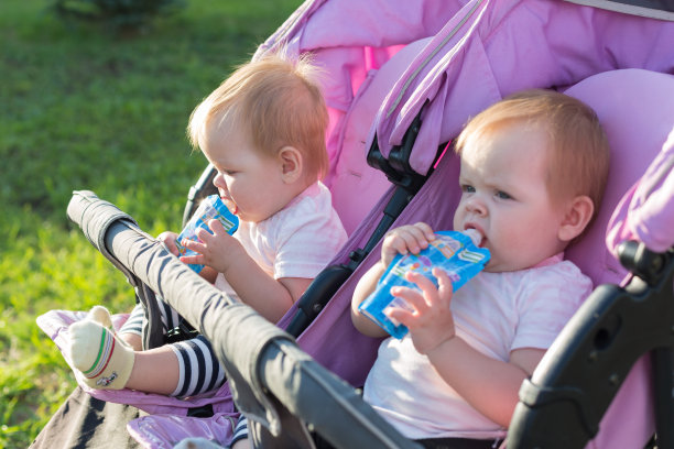饥饿的双胞胎女孩手拿土豆泥在街上的肖像图片下载