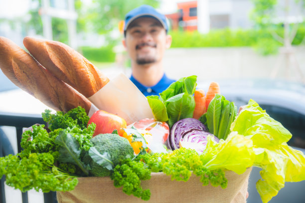 一个面带微笑的好男人，快速将食品杂货送到顾客家中，在检疫期间网购新冠肺炎，食品装在环保纸袋里，用心工作图片下载