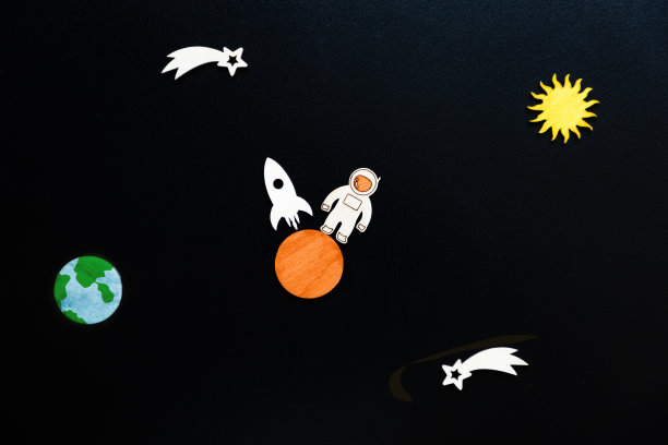 火星殖民。以宇航员和火箭的形式在火星上着陆的木制工艺品。黑色背景，平铺。太空旅行的概念图片下载