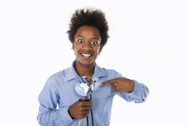 一个年轻的黑人男孩一手拿着放大镜，展示着非洲大陆的项链。图片下载