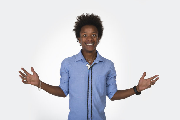 一个来自孤立背景的年轻黑人举起手臂兴奋地尖叫着，疯狂地庆祝着成功。图片下载