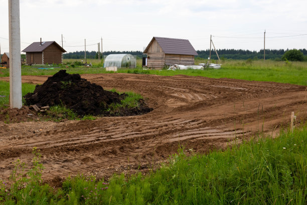 一堆黑钙土和一条正在修建的道路在一个别墅的地块上图片下载