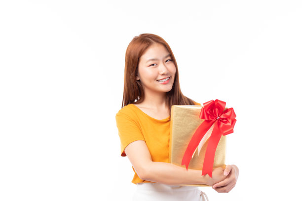 在圣诞节，新年，情人节，生日庆祝概念的亚洲女人持有礼品盒。肖像微笑快乐漂亮的女孩抱礼盒孤立在白色与复制空间。图片下载