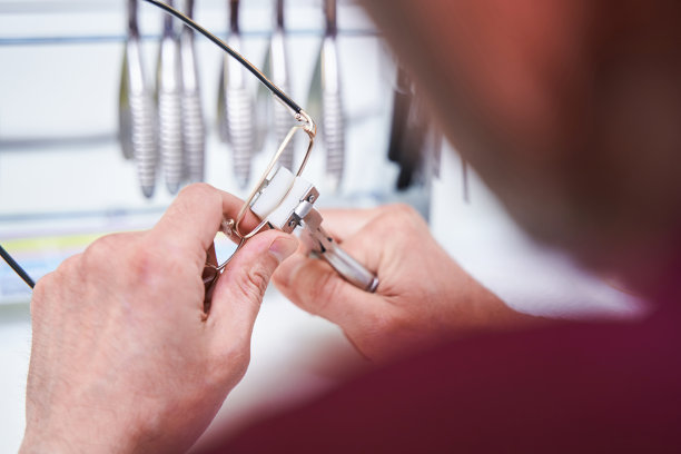 男配镜师在车间修眼镜图片下载