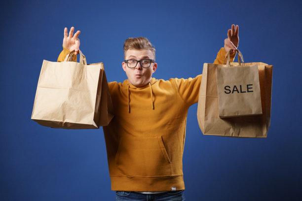 这名男子脸上露出了滑稽的表情，手里拿着从商店买来的纸袋，上面写着“出售”。图片下载