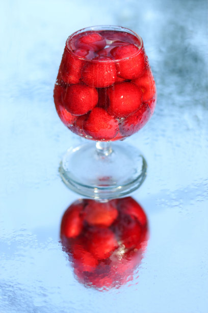 杯子里的樱桃。浆果酒精饮料概念。红酒。樱桃微距细节特写。春天的浆果。季节性的浆果。模糊背景上的樱桃酒或烈酒。自制的红樱桃酊图片下载