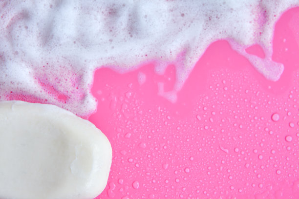清洗的概念。粉红色背景上的泡沫和肥皂。清洁服务图片下载