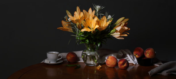 全景静物与一束鲜花，桃子和一杯咖啡在一个黑暗的背景图片下载