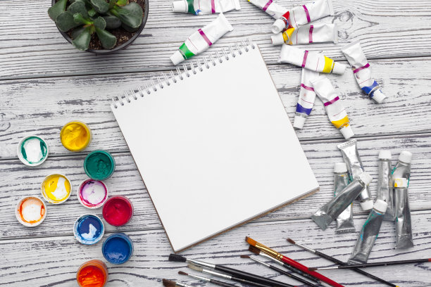 绘画工具，文具用品，艺术家工作场所。木桌上的水彩颜料和空白记事本图片下载