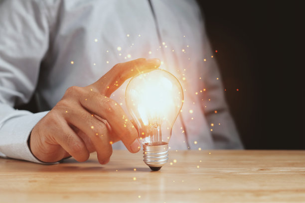 商人触摸着一个明亮的灯泡。创意的概念是呈现新创意的伟大灵感和创新的新起点。图片下载