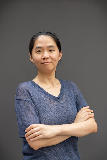 灰色背景下的成熟女性双臂交叉图片下载