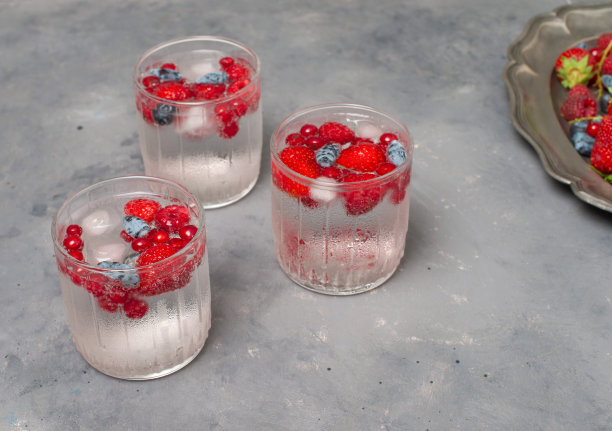 清凉的夏季饮料，浆果和苏打水。三杯水果柠檬汁，灰色背景。图片下载