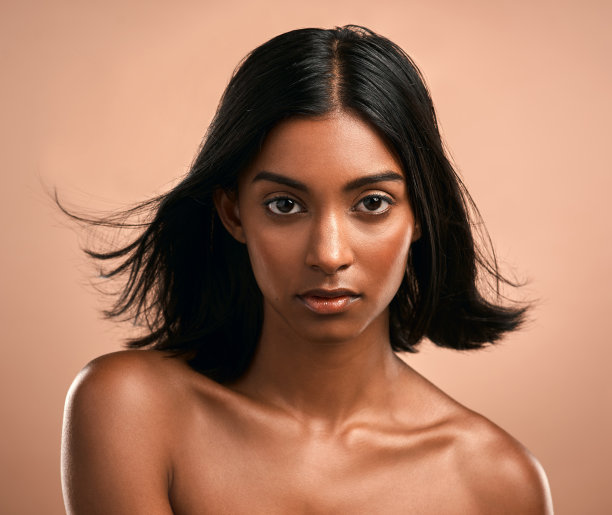 在棕色背景前摆姿势的年轻漂亮女子肖像图片下载