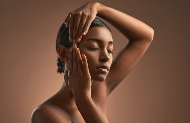 年轻美女在棕色背景前摆姿势图片下载