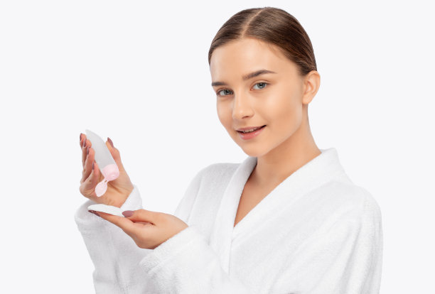 美丽微笑的女人与干净的皮肤拿着一个棉垫。她用爽肤水清洗皮肤。美容和专业皮肤护理。图片下载