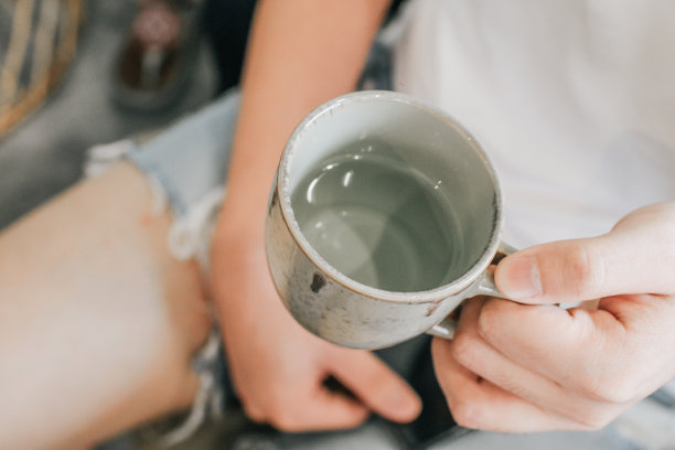 一个拿着陶瓷水杯的人。手捧一杯纯净水。喝健康饮料的男人图片下载