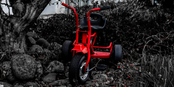 红色三轮车与深色木制背景图片下载