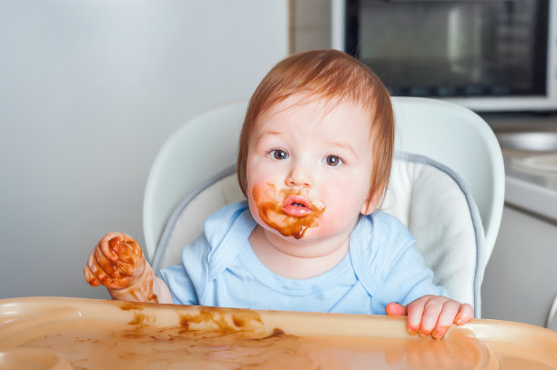 婴儿在高椅子上覆盖着水果，蔬菜泥特写。补充喂养tredhead oddler概念。图片下载