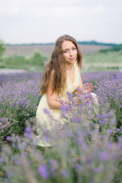 年轻漂亮的白种人长发女子，穿着淡黄色连衣裙，喜欢薰衣草色。图片下载