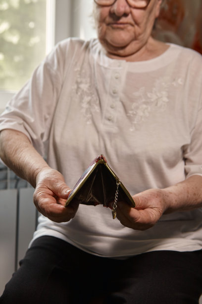 年长的女人数着钱。一位白发苍苍的白种老妇人从钱包里拿出钱，数了数。老手手里拿着钞票。图片下载