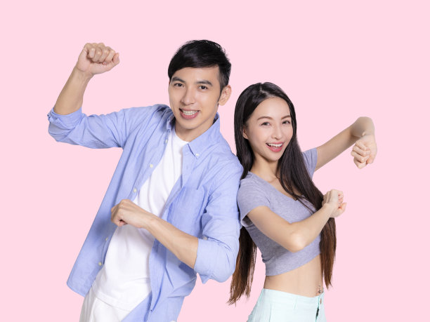 幸福的夫妇庆祝胜利孤立的粉红色背景。图片下载