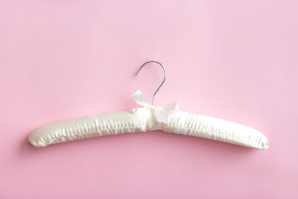 空的白色衣架在明亮的粉红色背景与拷贝空间图片下载