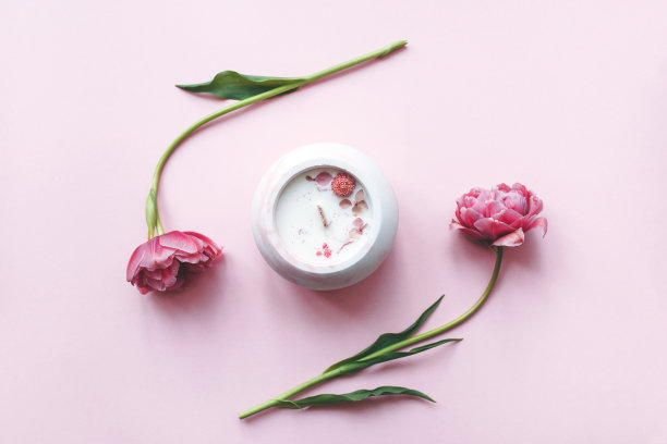 生态和纯素手工蜡烛与干花在玻璃制成的混凝土在粉红色的背景和粉红色的郁金香。大豆或椰子蜡烛与木芯。图片下载