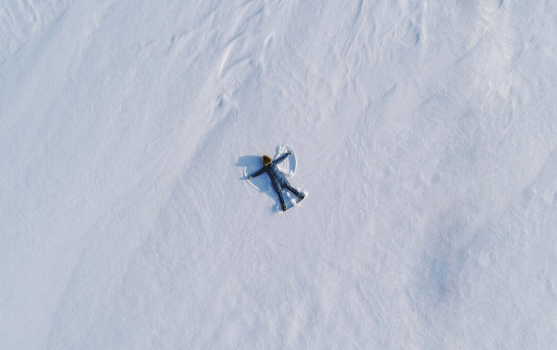 女人在雪地里做了一个雪天使。前视图。空中有意者。图片下载