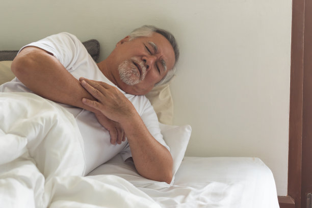 上了年纪的亚裔男子因心脏病在床上疼痛。图片下载