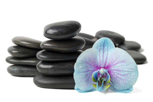 水疗概念-堆叠的黑色按摩石和兰花孤立在白色图片下载