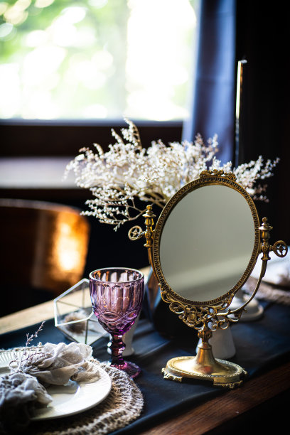 复古的古董表。桌子上的摆设，古董镜子，盘子，古董杯子。桌子上有一面古老的镜子图片下载
