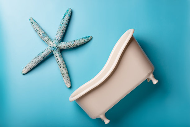 蓝色背景上有海星的空玩具浴缸。清洁、卫生的概念。图片下载
