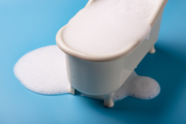 玩具浴与流动的肥皂泡沫在蓝色的背景。清洁、卫生的概念。图片下载