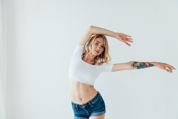 美丽的金发女子在训练中随着音乐跳舞图片下载