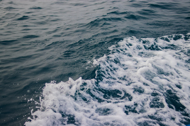 印度尼西亚传统渔民摩托艇旁的海水飞溅和泡沫图片下载